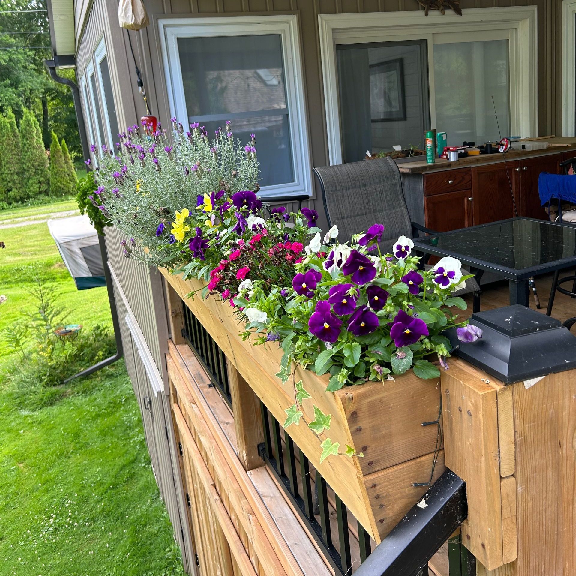 A wooden box filled with purple and yellow flowers