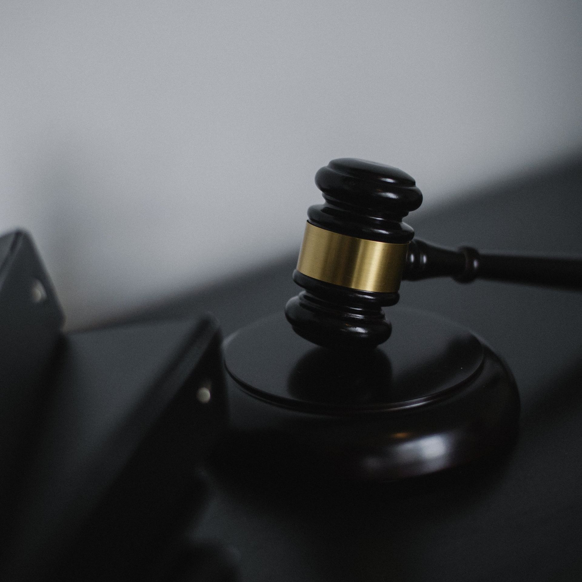 A judge 's gavel is sitting on top of a black table.