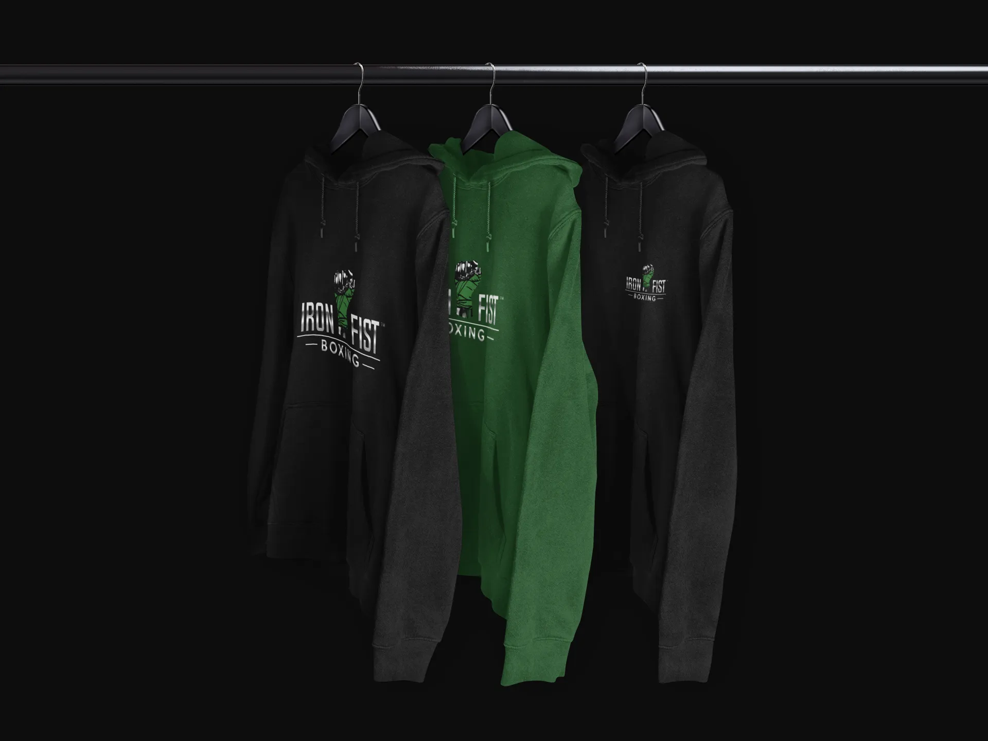 Three Iron Fist Boxing hoodies are hanging on a rack