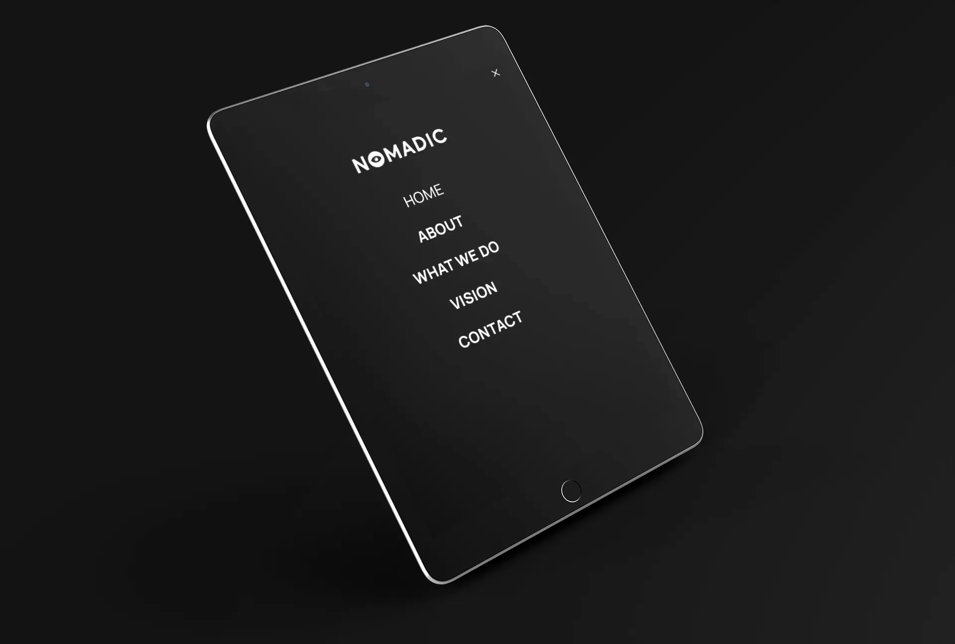 A black tablet displays Nomadic Vision website navigation menu