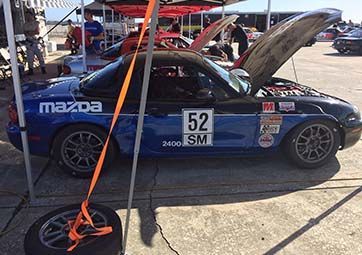 A blue mazda car with the number 52 on the side