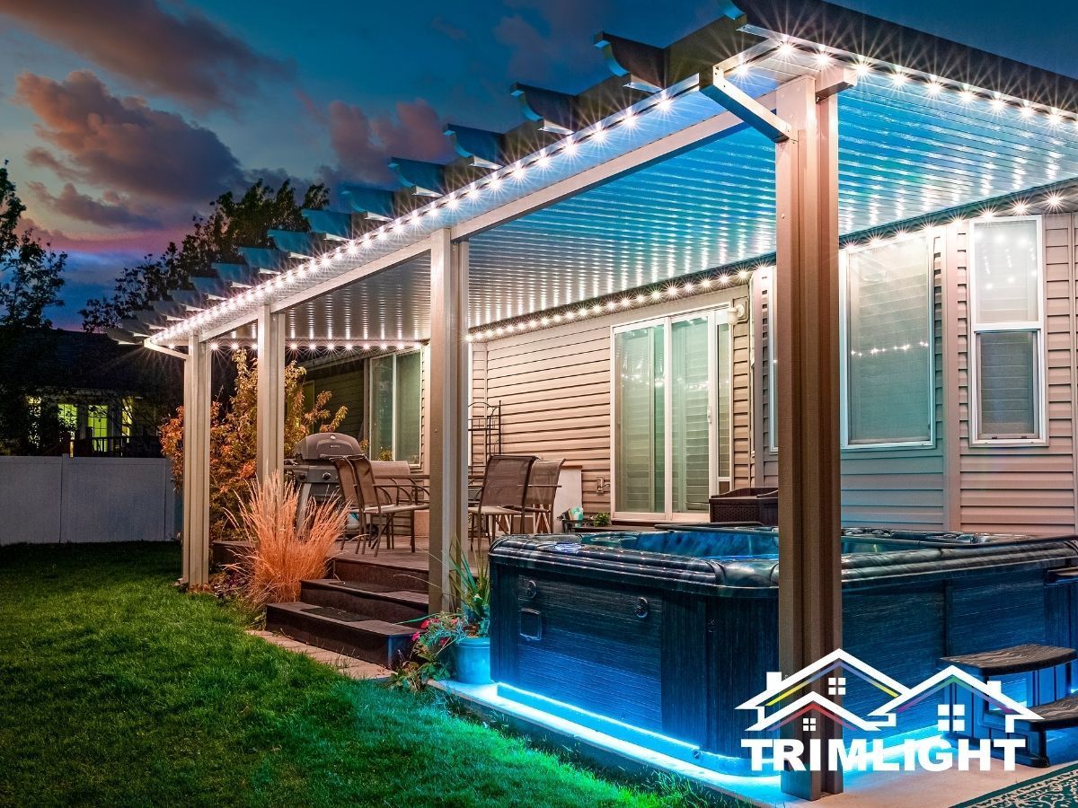 Patio with string lights and a hot tub illuminated with blue lights at dusk.