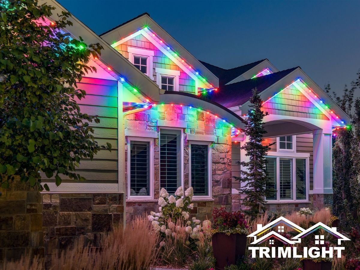 House illuminated with colorful LED lights along the roofline, with Trimlight logo in the corner.