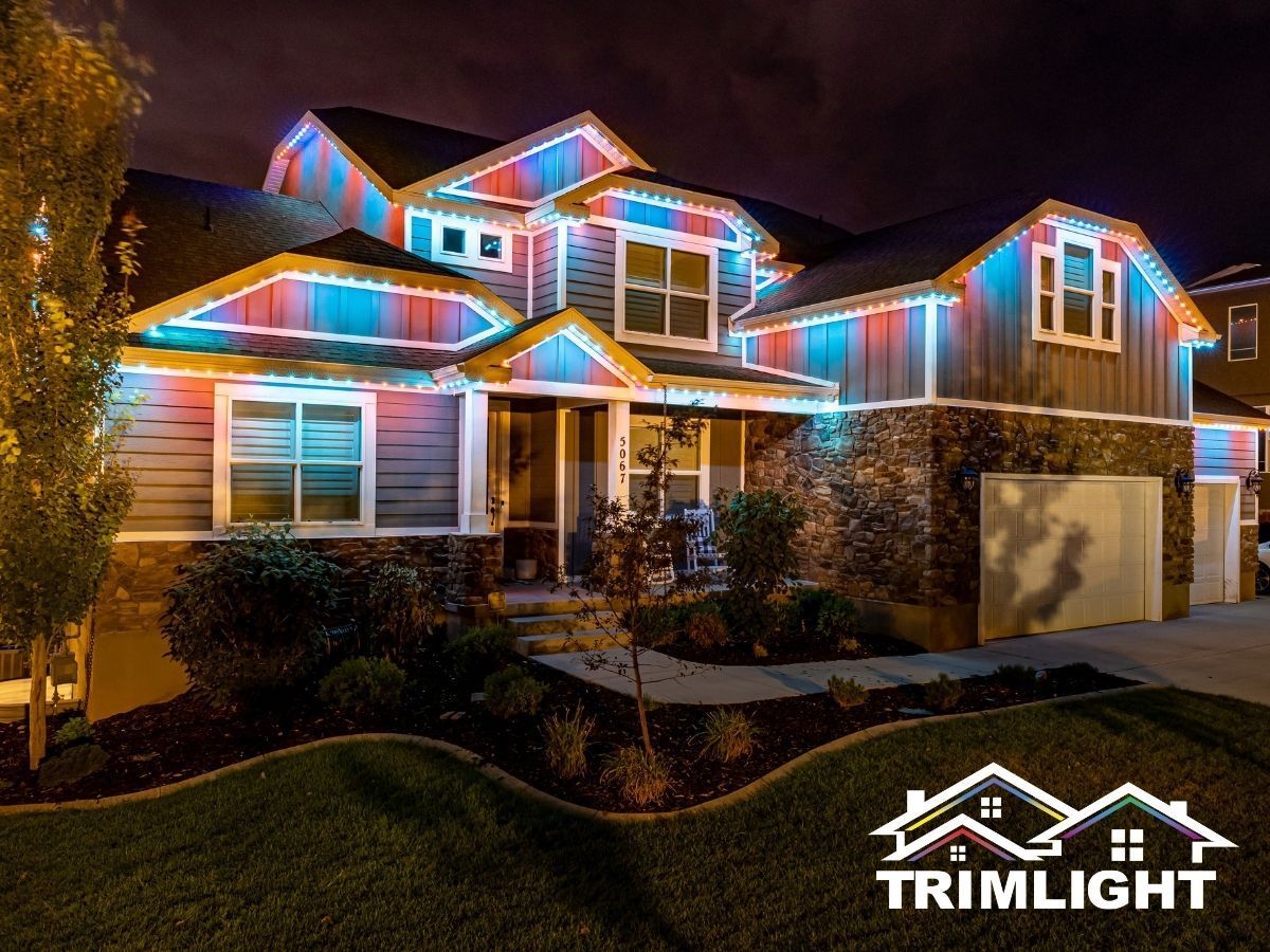 House exterior lit with red, blue, and green lights along rooflines and trim at night; Trimlight logo.
