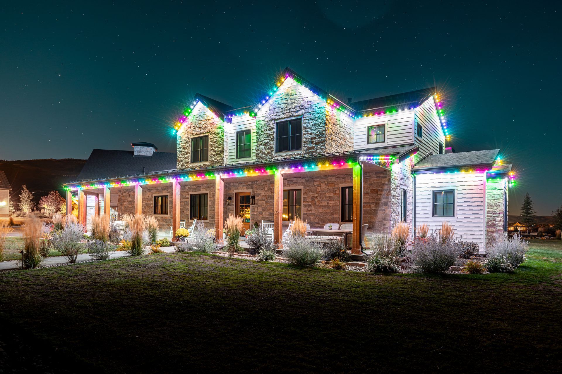 House decorated with colorful Christmas lights against a night sky.