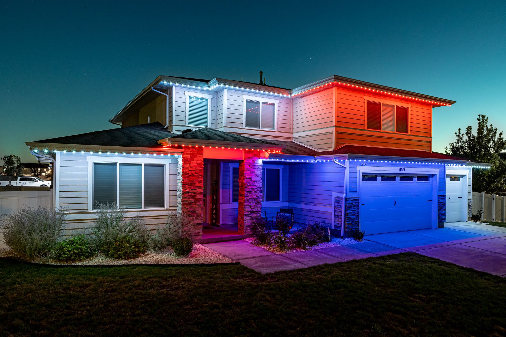 House with multi-colored LED lights on roof and around windows; blue, white, and red.