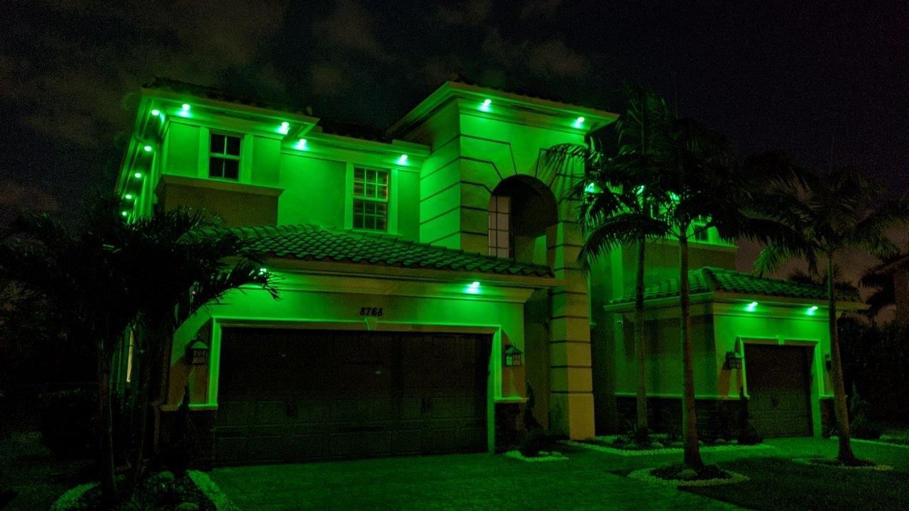 House lit with bright green lights at night.