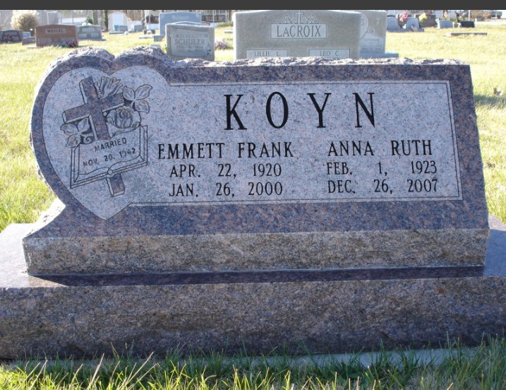 White marble bench on gray paving stones, with green grass in the background.