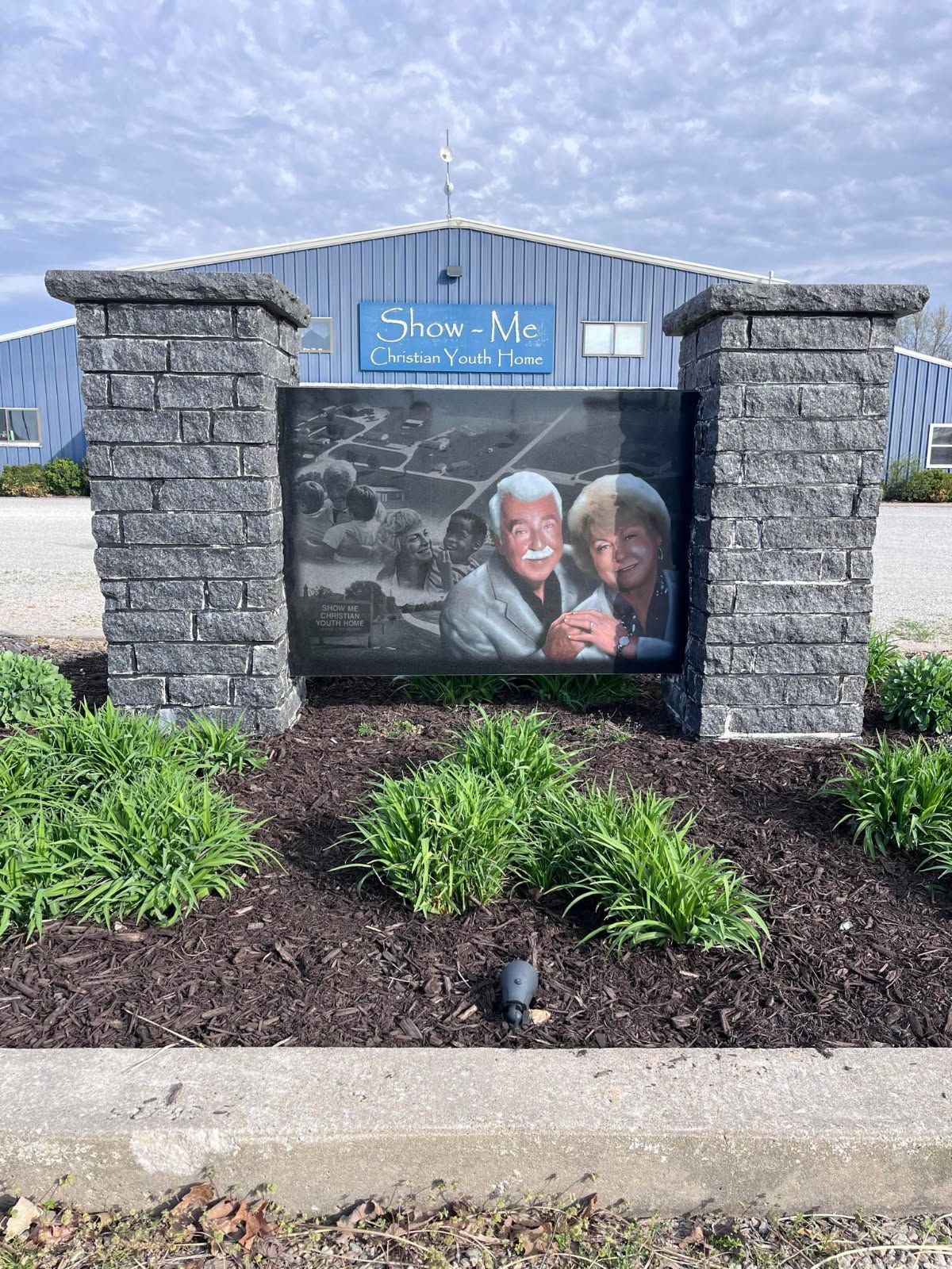Stone bench on grass; sunny outdoor setting.