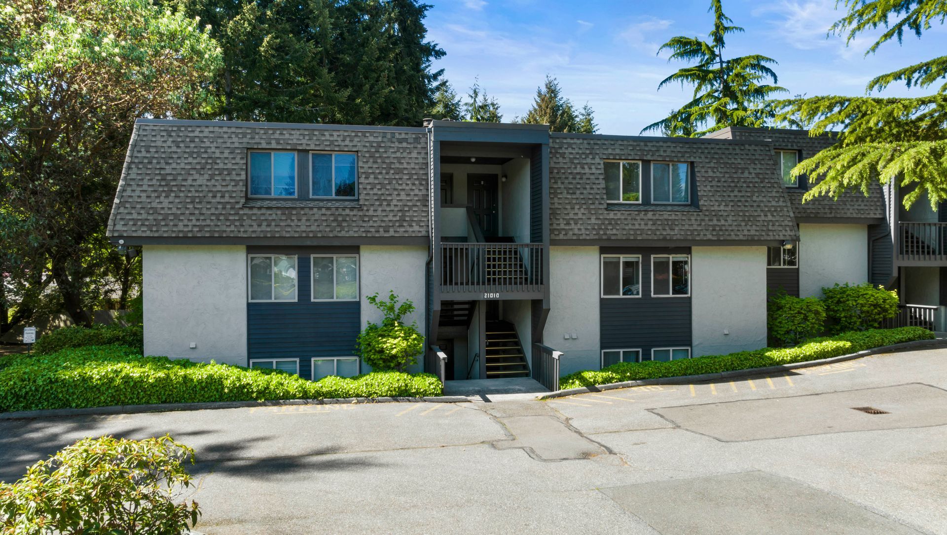 a large apartment building with a lot of windows and trees in the background .
