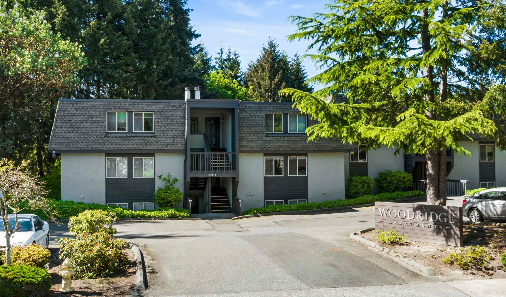 a house with a lot of windows is surrounded by trees