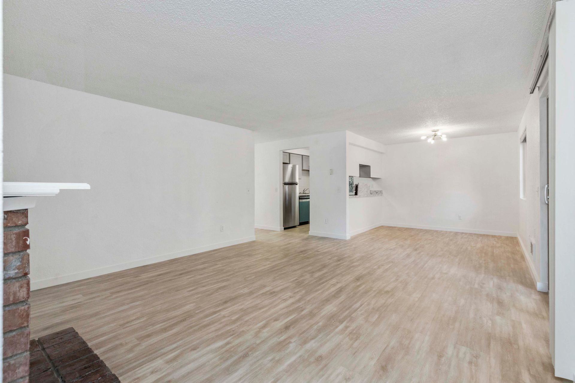 an empty living room with hardwood floors and white walls .