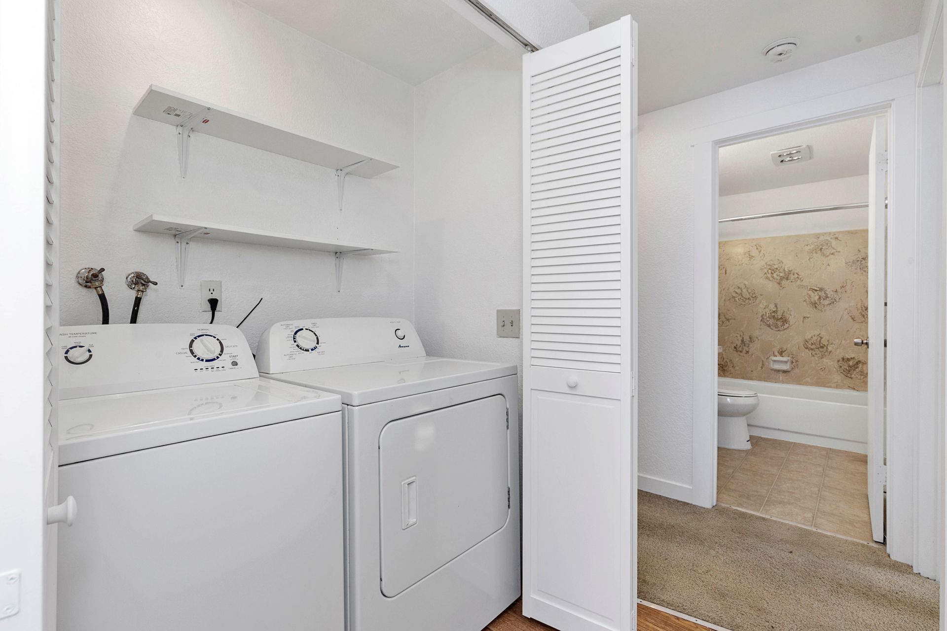 a laundry room with a washer and dryer and a bathroom .