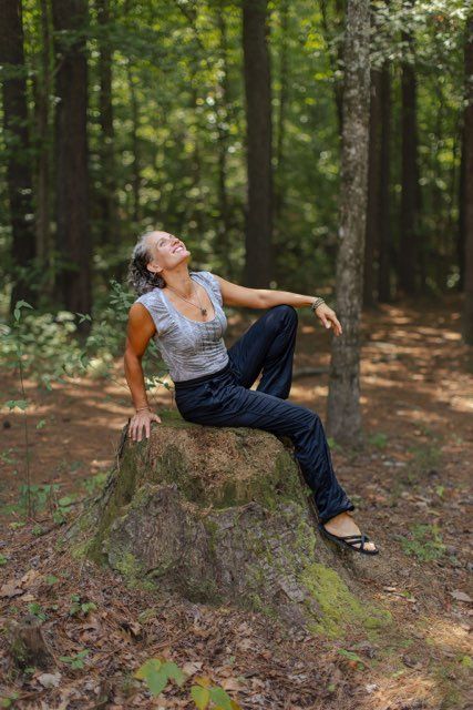 Woman in teal workout clothes meditates outdoors with eyes closed.