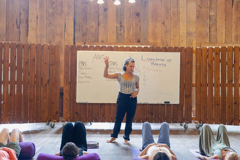 Woman with arms outstretched, smiling at the bright blue sky at the beach.