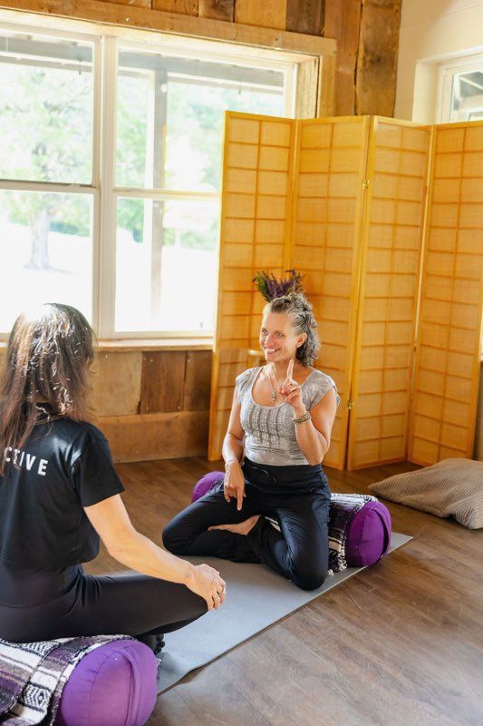 Massage therapist giving a back massage, hands kneading. Person on a massage table. Beige walls, charts in background.