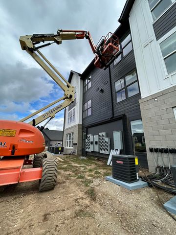 A crane is sitting in front of a building under construction.