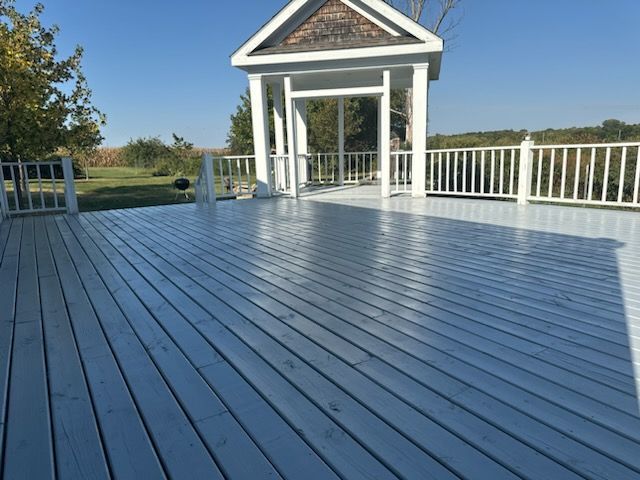 A white deck with a gazebo in the background