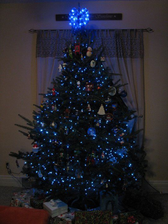 A Christmas tree with blue lights and a heart on top