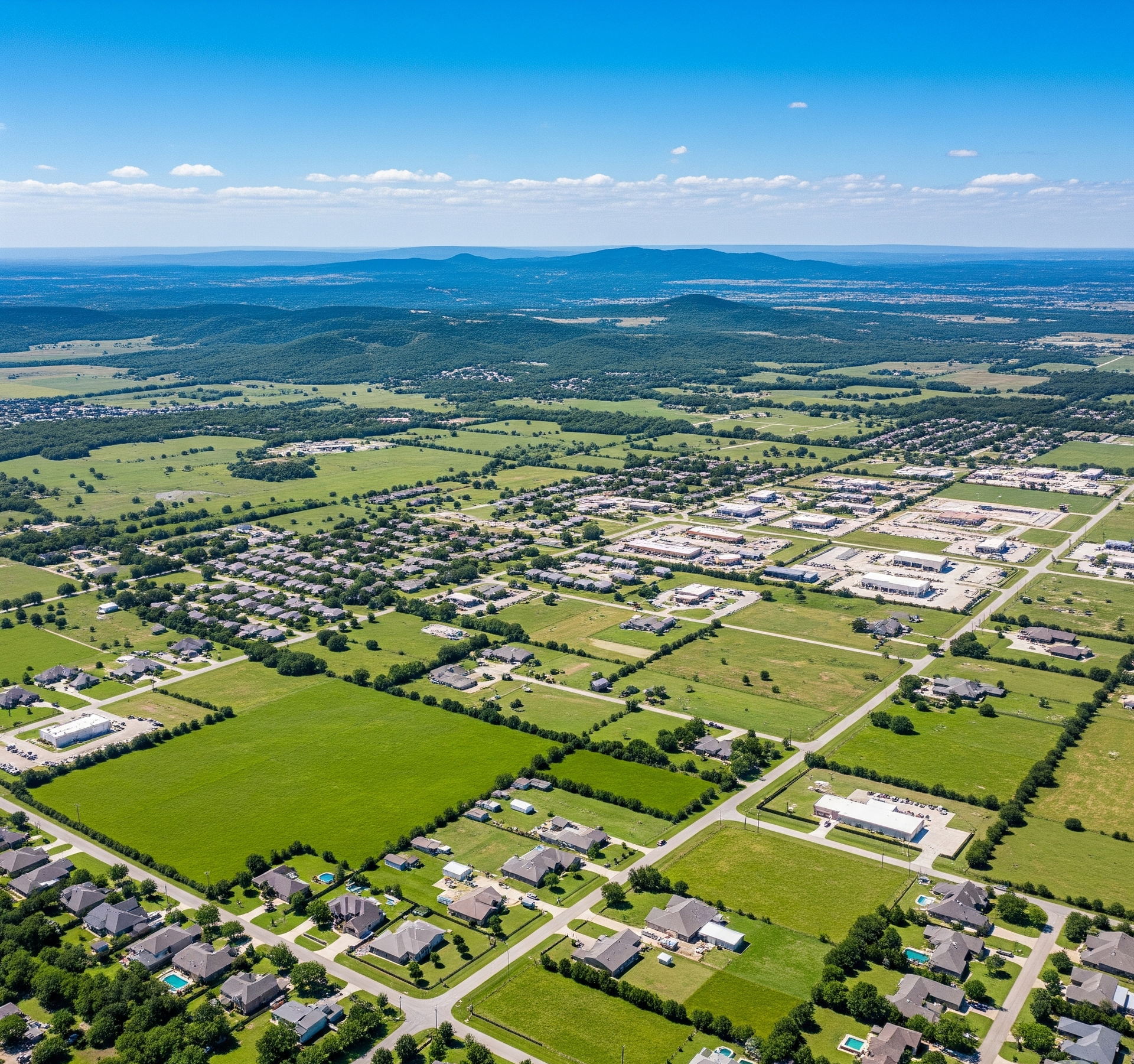 An aerial view of a river surrounded by fields and houses.