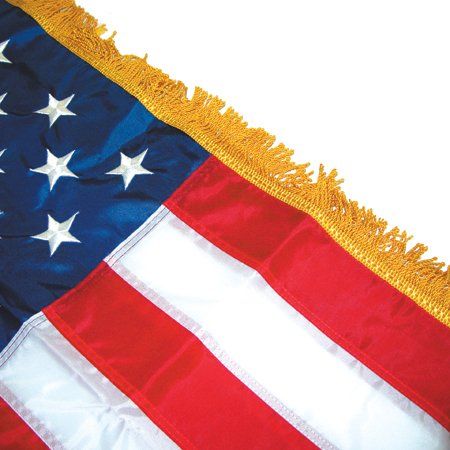 A close up of an american flag with gold fringe