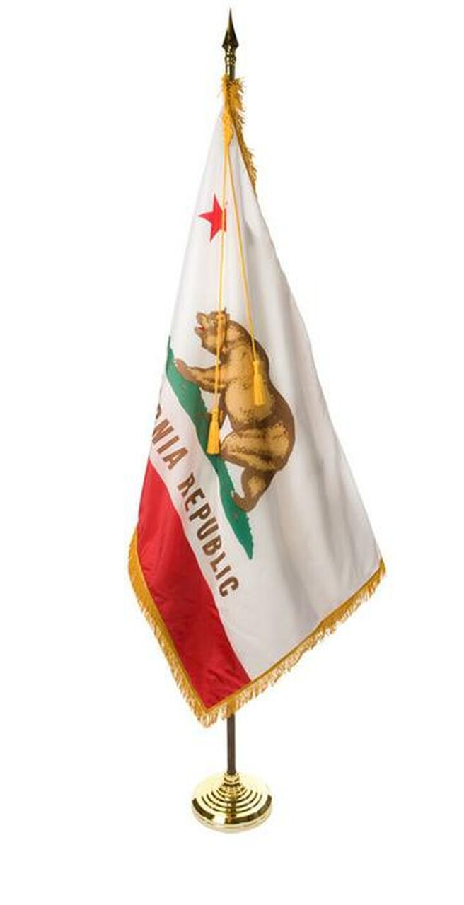 A small california flag on a gold stand on a white background.