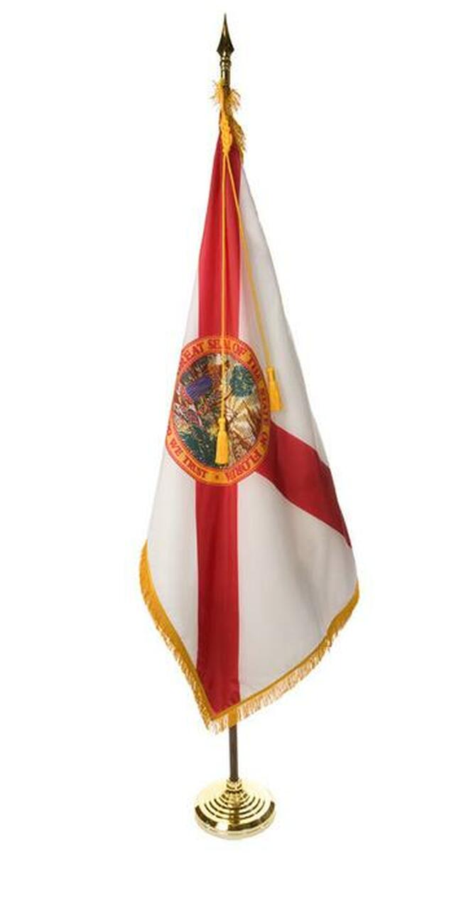 A small flag on a gold stand on a white background.