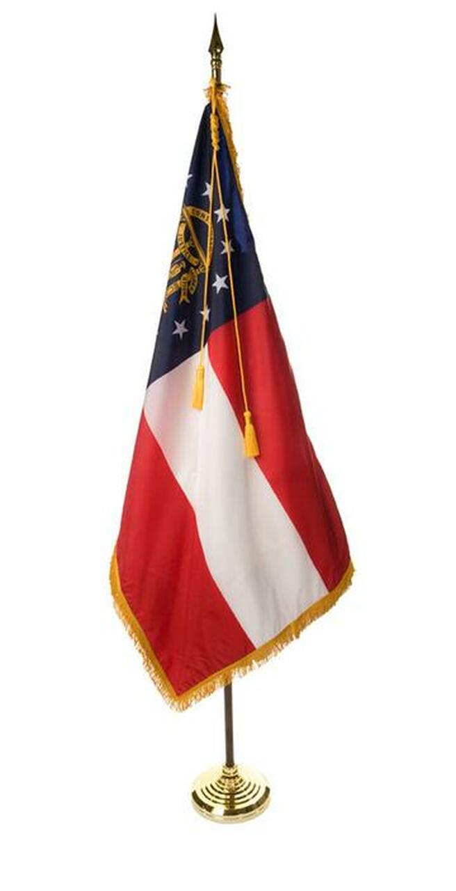 A small american flag on a gold pole on a white background.