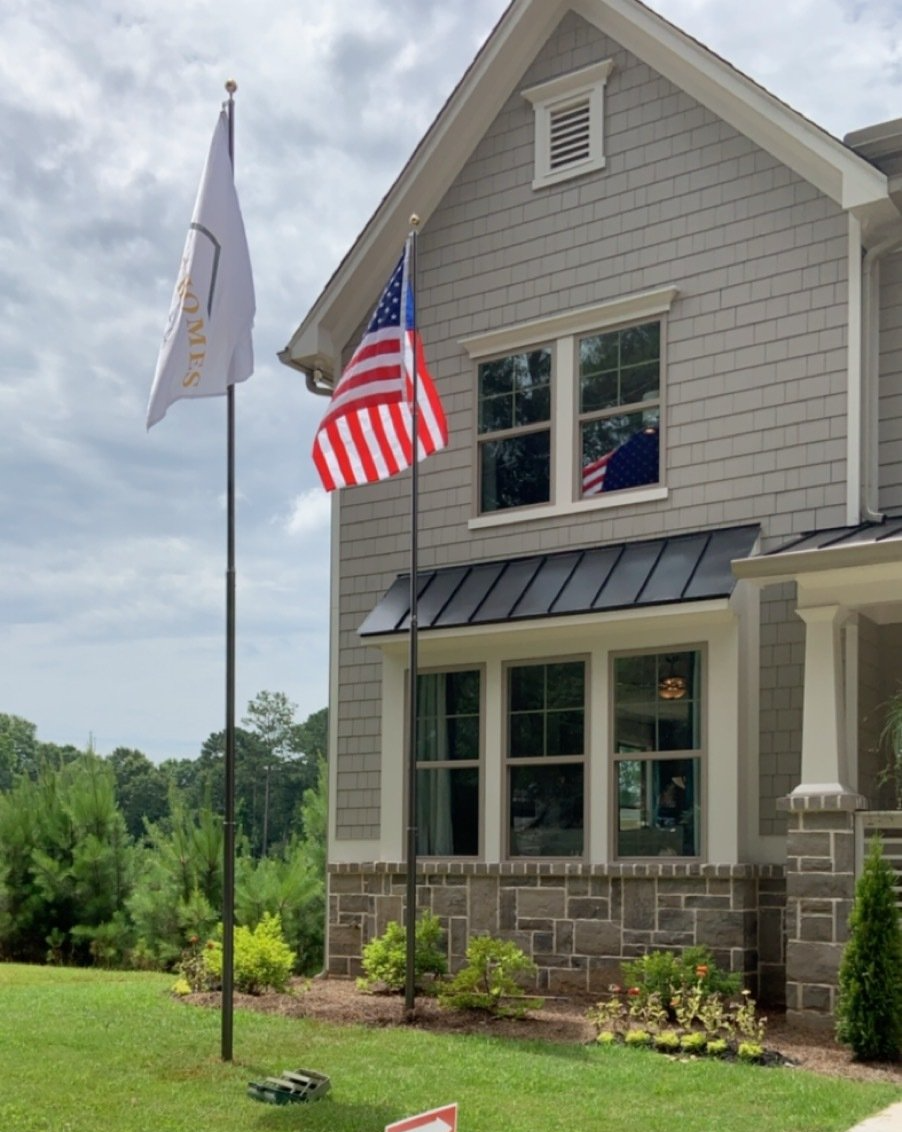 An american flag is flying in front of a house