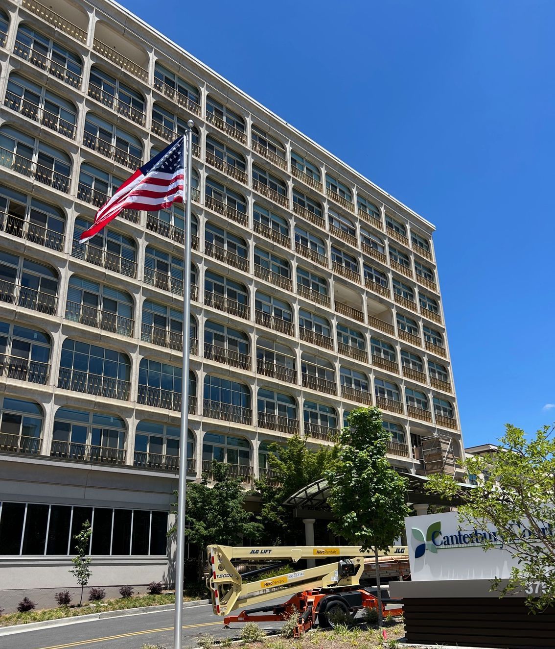American Flag and Flagpole Display in Front of a Large Building