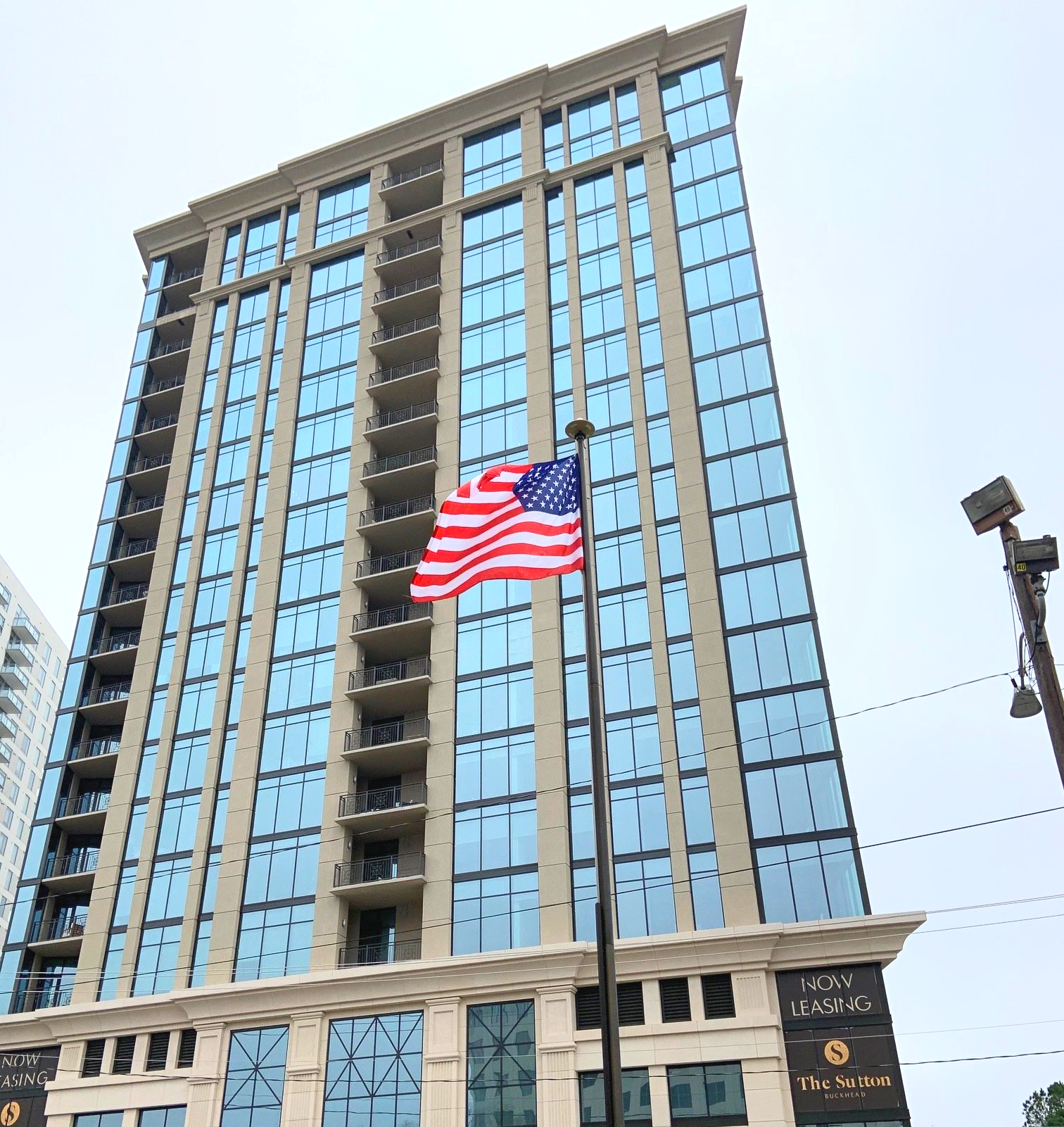 An american flag is flying in front of a tall building