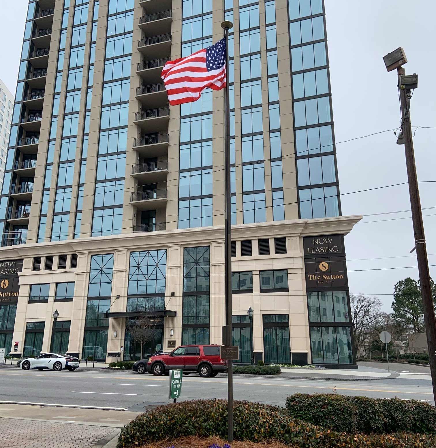 An american flag is flying in front of a tall building