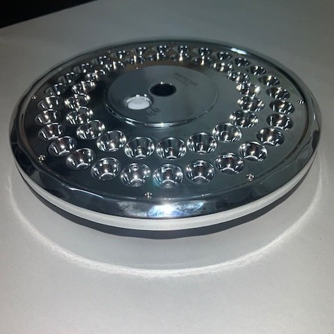 A silver plate with holes in it is sitting on a white surface
