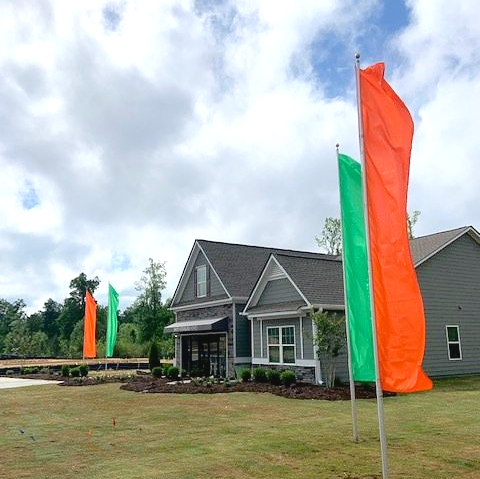 A house with a green and orange flag in front of it