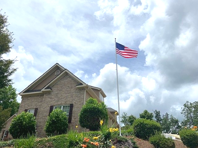 An american flag is flying in front of a house