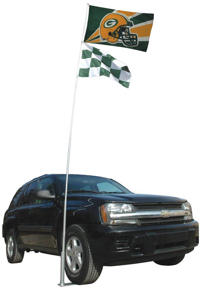 A black suv is parked next to a flag pole with two green bay packers flags on it.