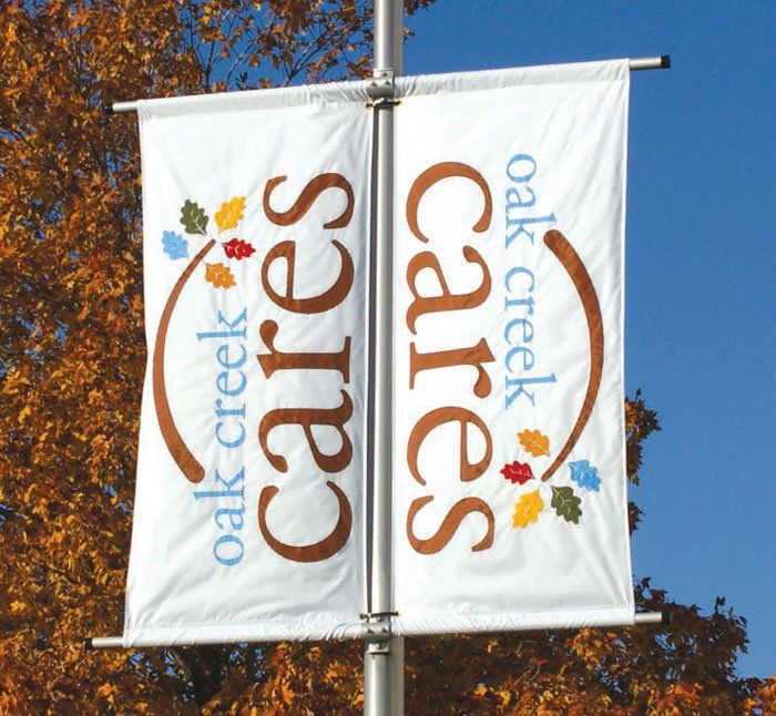 A banner for oak creek cares hangs from a pole