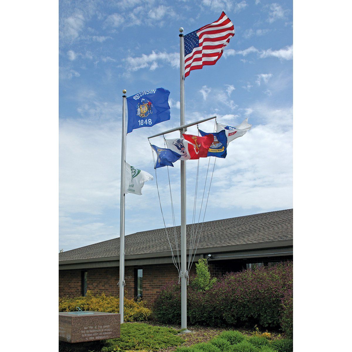Three flags are flying in front of a building