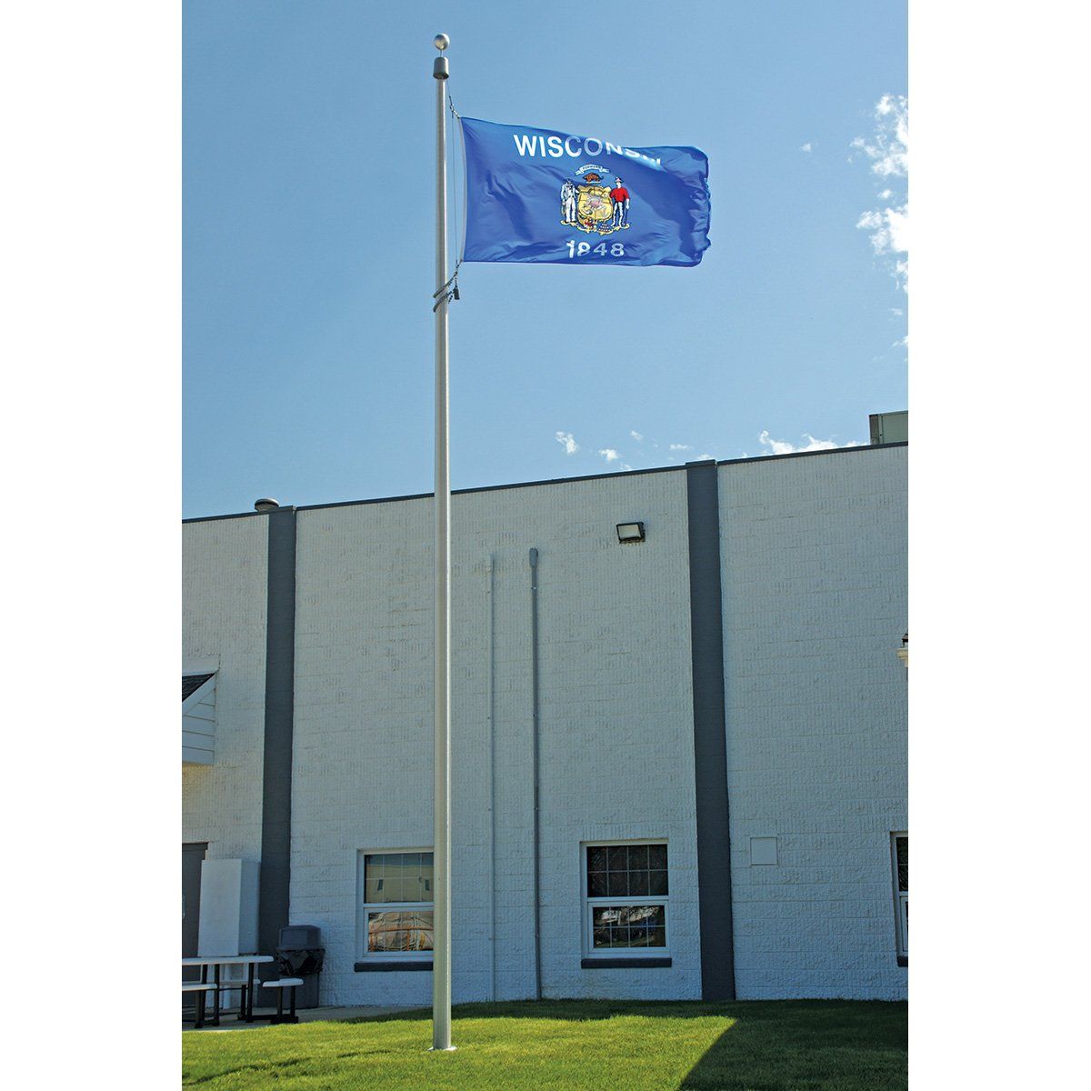 A blue wisconsin flag is flying in front of a building
