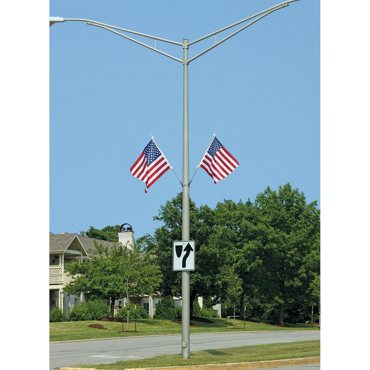 A street light with two american flags hanging from it