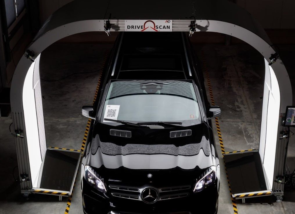 A black Mercedes passes under a 