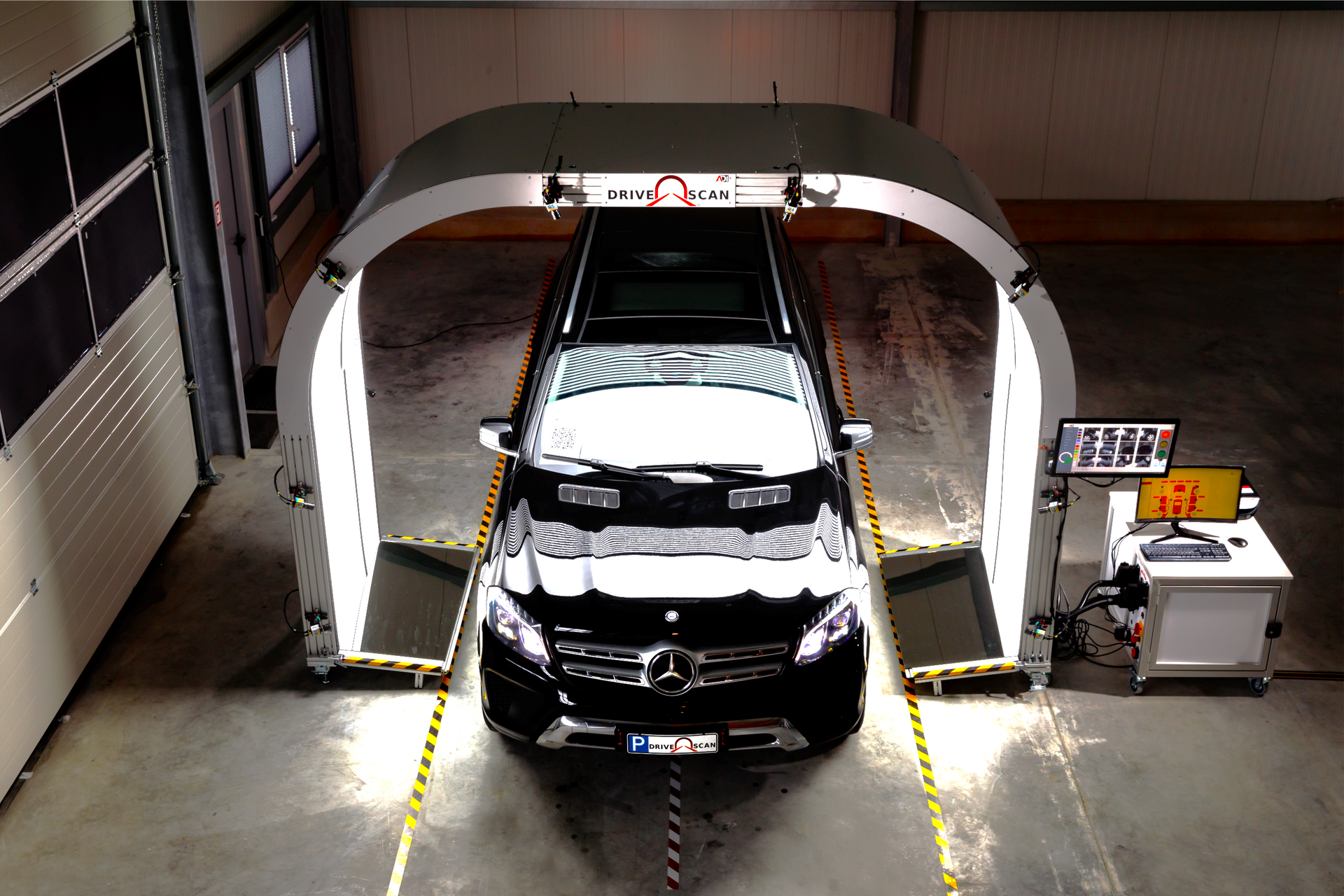 Car inside a white portal. Inspection equipment surrounds a black Mercedes-Benz for measurement and analysis.