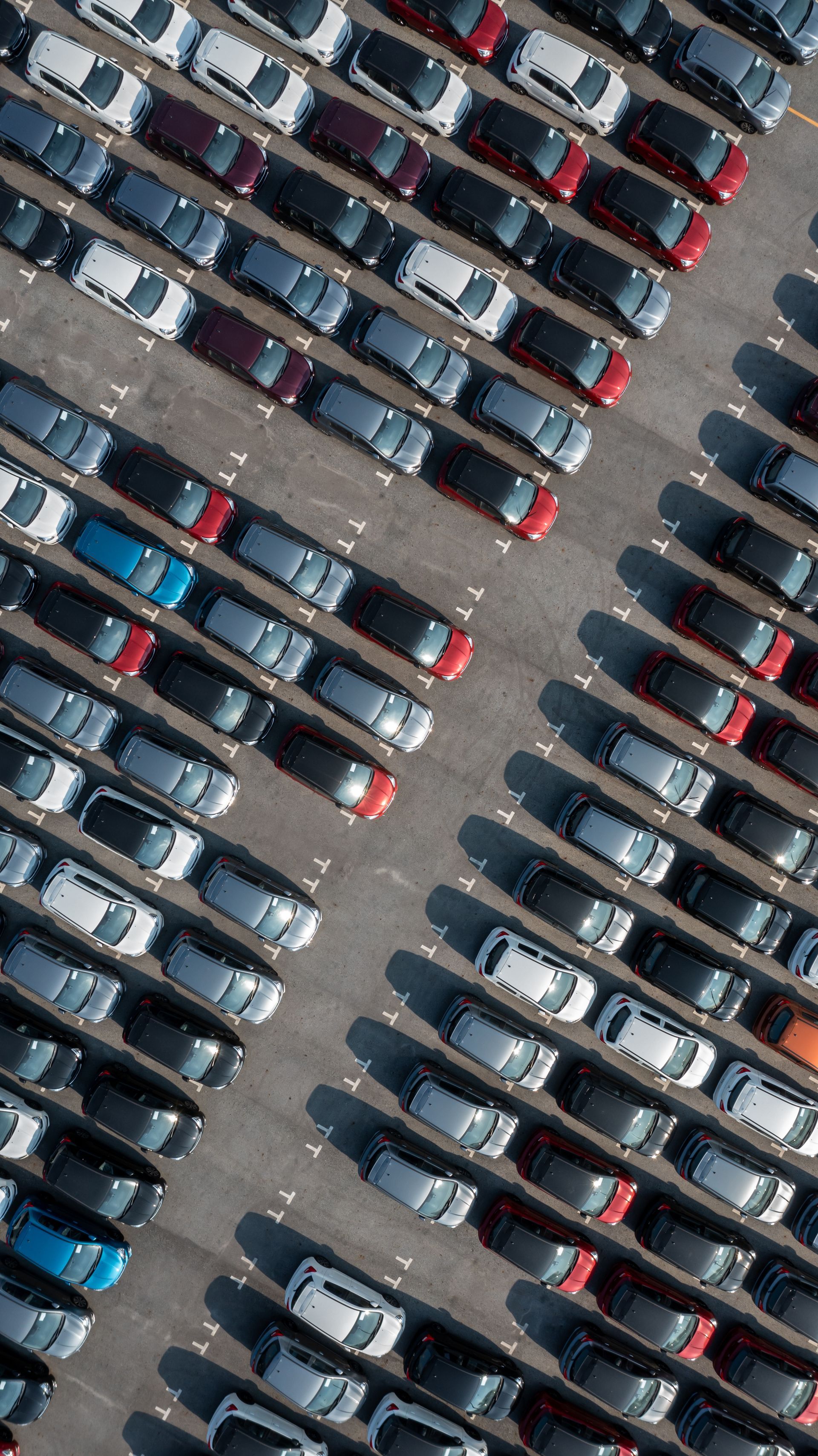 an aerial view of a parking lot filled with lots of cars .