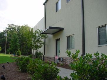 A white building with a canopy over the door