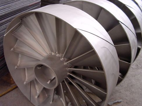 A large stainless steel fan is sitting on the ground