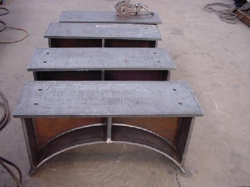 A row of metal benches are lined up on the ground