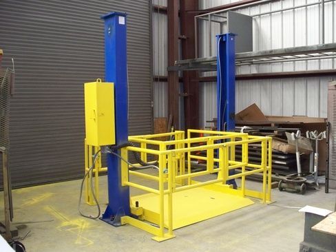 A blue and yellow machine is sitting in a warehouse.
