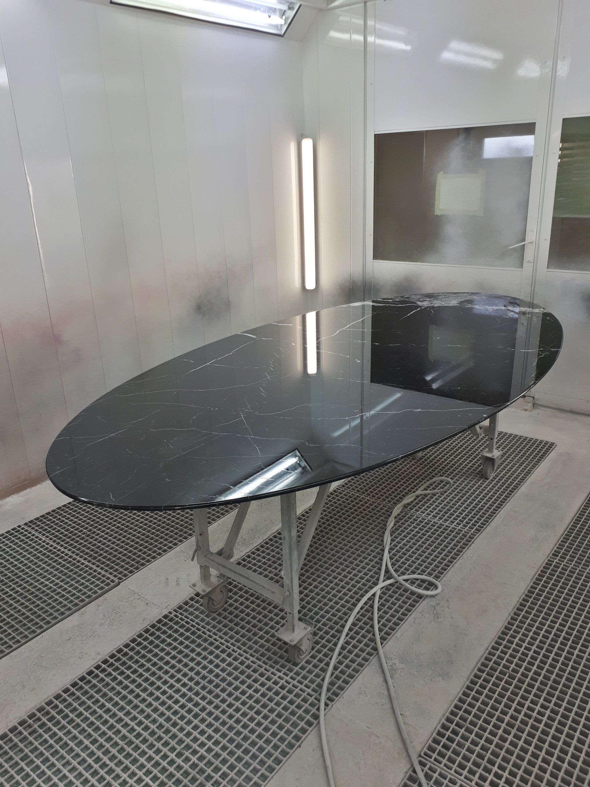 Une grande table en verre noir se trouve dans une pièce.