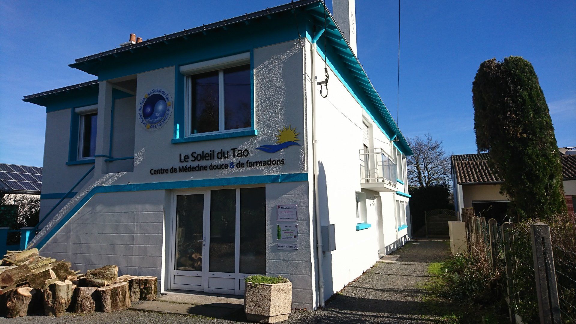Un bâtiment blanc avec une bordure bleue porte le mot le soleil dessus