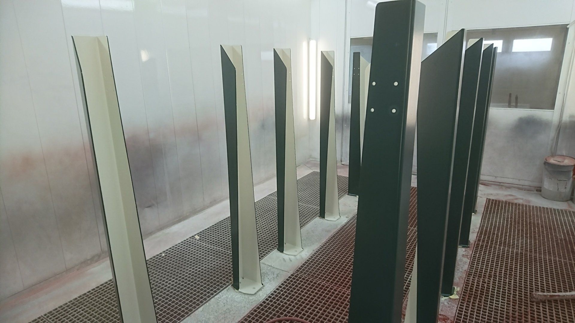 Une rangée de piliers noirs et blancs est alignée dans une pièce.